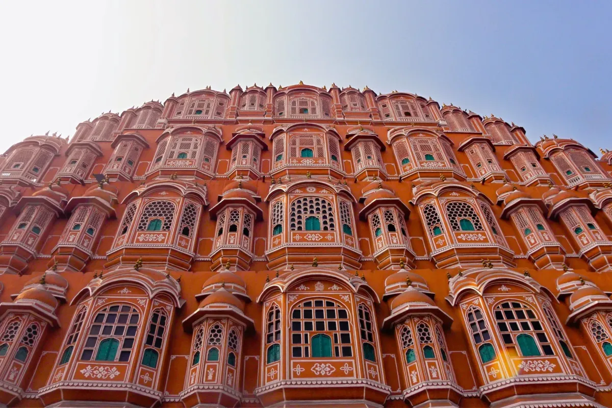 The pink honeycomb facade of Hawa Mahal in Jaipur against a pale sky
